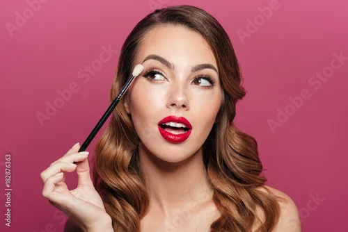 Obraz Young pretty lady making make up with brush for eyes isolated