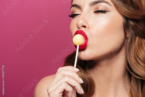 Beautiful lady enjoy and lick lollipop isolated photo