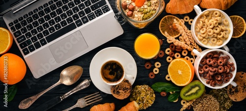 Fototapeta Naklejka Na Ścianę i Meble -  Business breakfast, muesli, coffee, milk, fruits, nuts and seeds, on a wooden surface. Top view. Free space for text.