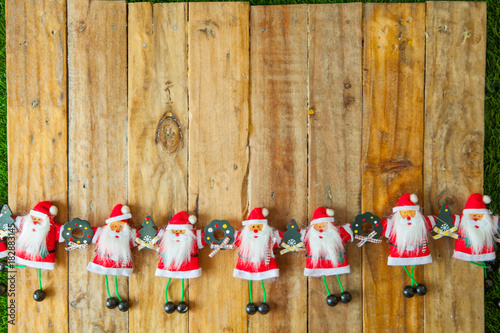 Christmas background with santa claus doll holding hands on wooden table background with a copy space