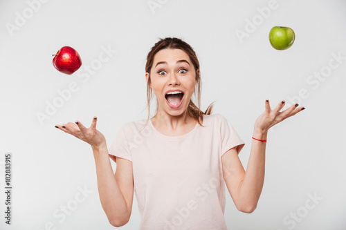 Portrait of a happy girl throwing apples in the air