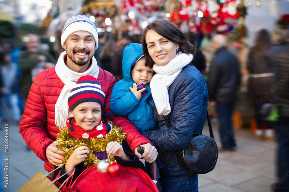 Obraz premium Parents with kids choosing X-mas decorations in market