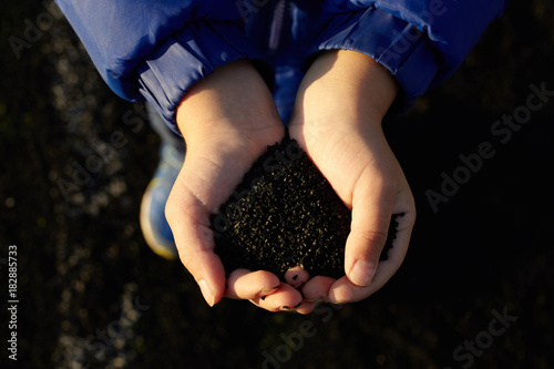 Kid's hands holdung black rubber. photo