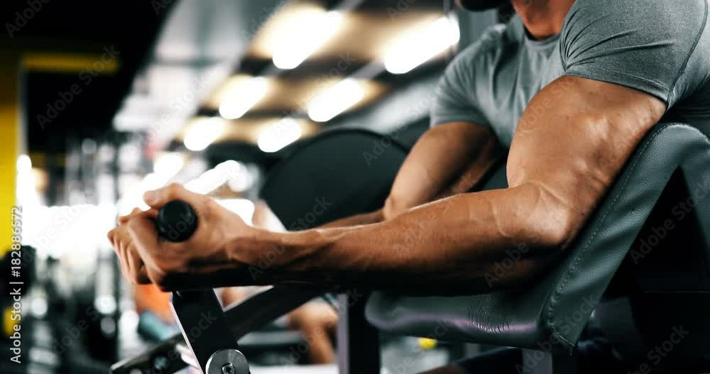 Young handsome man doing exercises in gym