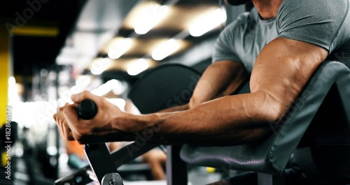 Young handsome man doing exercises in gym
