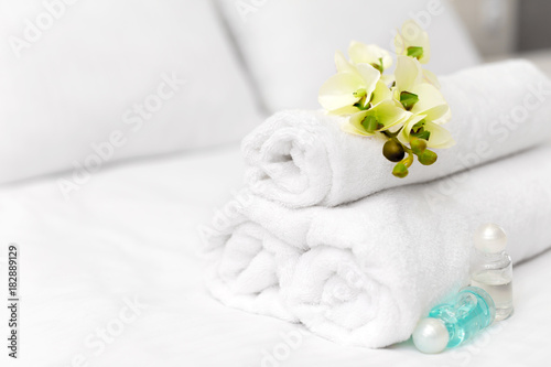 Fototapeta Naklejka Na Ścianę i Meble -  Stack of towels with flower decor in a hotel room