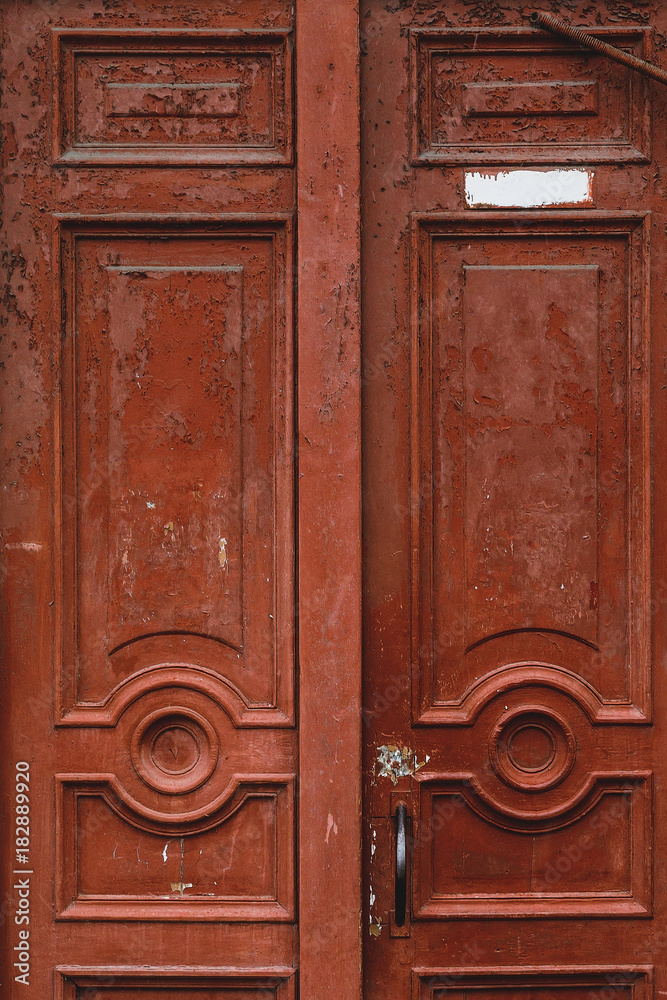 Closeup on an old and neglected wooden door with ironwork windows Closeup on an old and neglected wooden door with ironwork windows