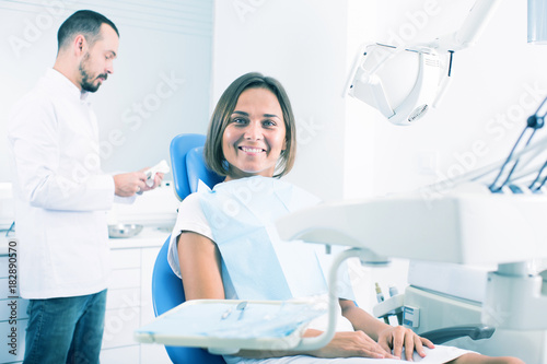 Girl is sitting satisfied after treatment in dental office