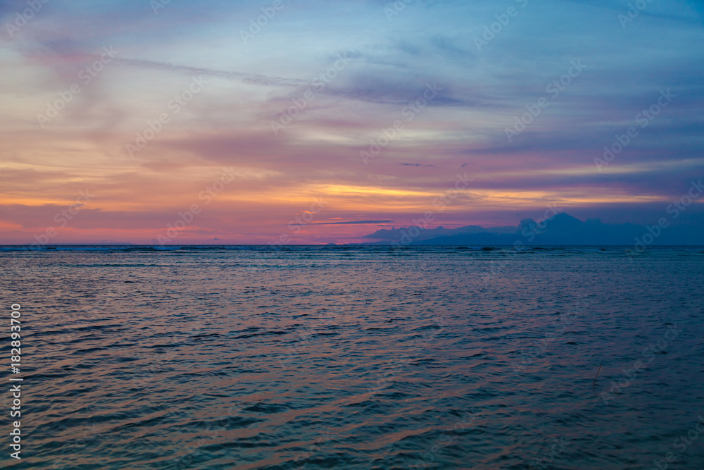 Obraz premium Beautiful sunset over the sea and volcano Agung silhouette on the island of Gili Trawangan, Indonesia