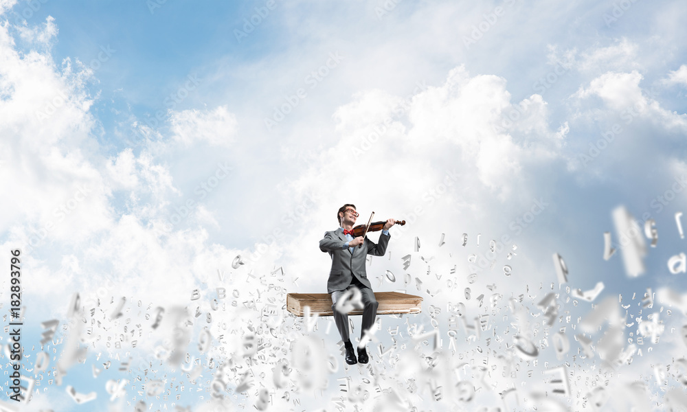 Handsome violinist play his melody and symbols fly around in air Handsome violinist play his melody and symbols fly around in air