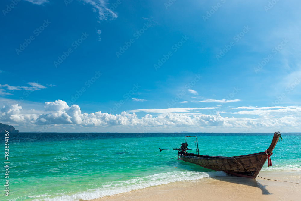 traditional Thai boat long tail near the shore in the turquoise sea, Poda island, Thailand