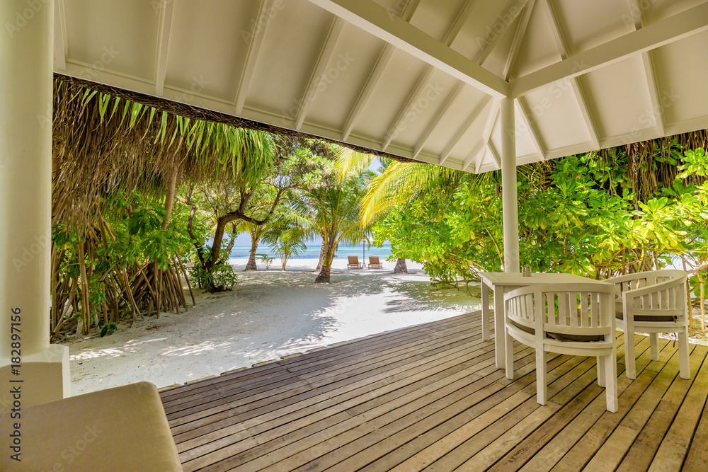 Luxury beach villa, calm tranquil beach scene and palm trees and blue sea