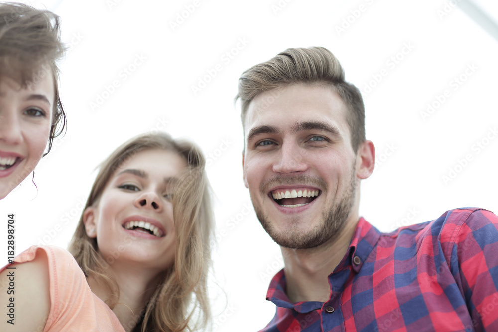 closeup of three young people smiling on white background closeup of three young people smiling on white background
