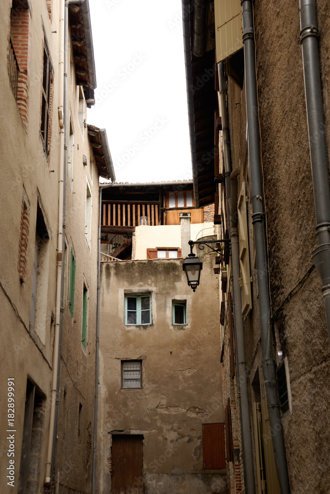 Narrow medieval street with old buildings in historical center of Cahors, France