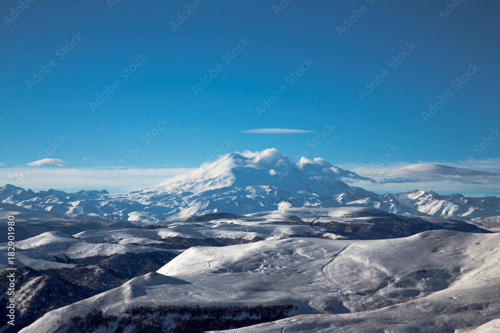 Красивый вид на высокую гору Эльбрус, снежные вершины, зимний пейзаж, природа и достопримечательности Северного Кавказа