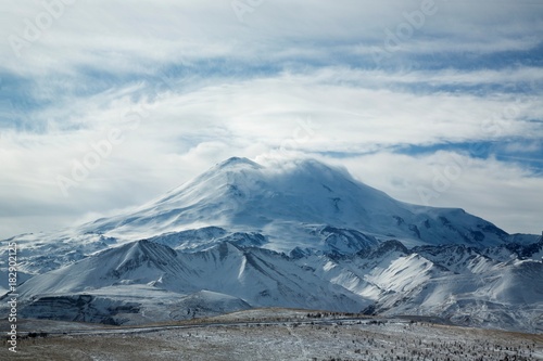 Красивый вид на высокую гору Эльбрус, снежные вершины, зимний пейзаж, природа и достопримечательности Северного Кавказа © Ivan_Gatsenko