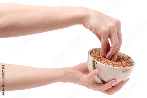 Buckwheat groats in a plate pial female hands