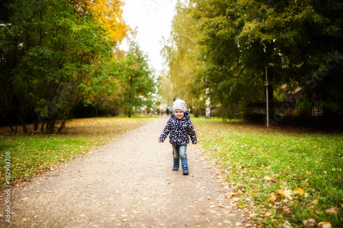 Wallpaper Mural the baby runs along the asphalt road in autumn in the park Torontodigital.ca