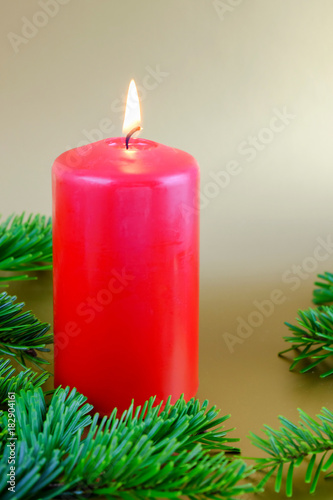 Christmas composition with red candle and fir branches.