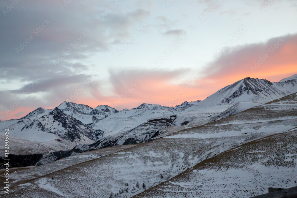 Зимний закат над снежными горами, красивые цвета на облачном небе, заход солнца, природа Северного Кавказа