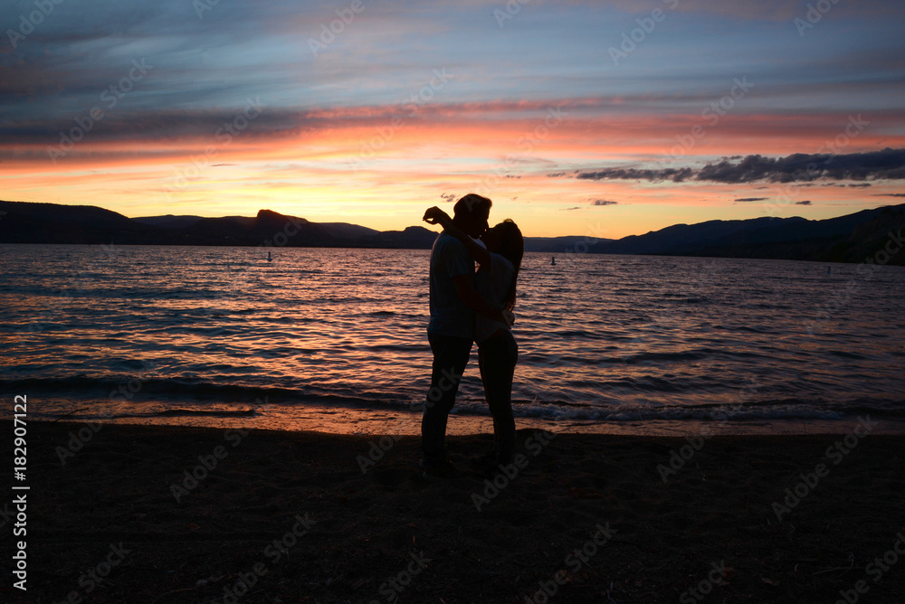 Couple kissing on sunset in front of the lake