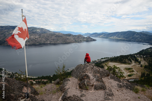 Girl standing in top of a mountain with a red hoodie in Peachland British Columbia, Canada photo