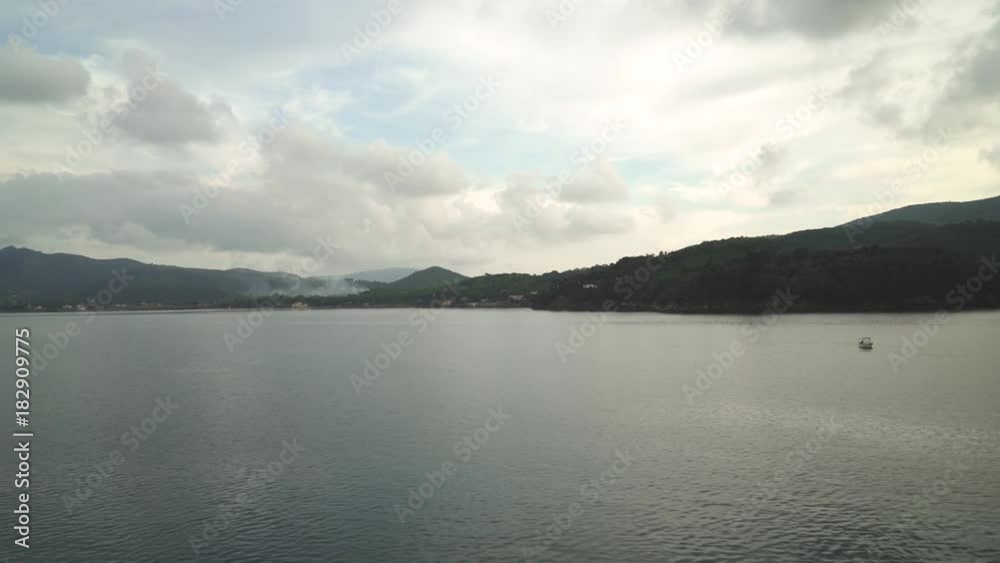 Beautiful green island seen from the sea on overcast weather Beautiful green island seen from the sea on overcast weather