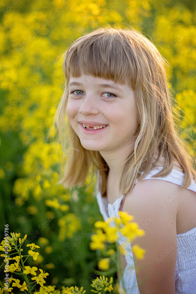 young blond toothless girl smiling at the camera 