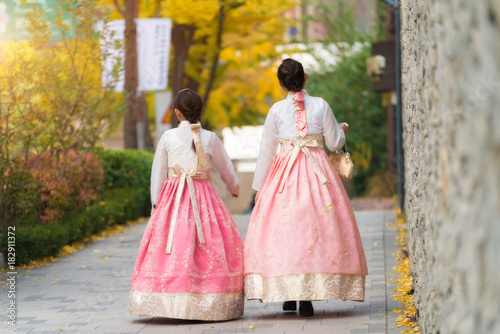 Asian Korean woman dressed Hanbok in traditional dress walking in Jeongdong-gil in Seoul, South Korea.. photo