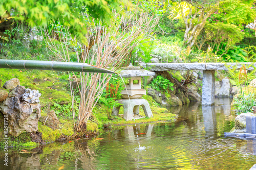 Japanese culture concept. Close up of traditional japanese bamboo fountain in Take-dera or hokoku-ji temple garden. Kamakura, Japan. Japanese temple and buddhism concept. photo