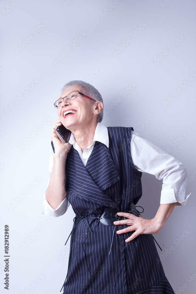 Classy senior lady talking on her cell phone, white background Classy senior lady talking on her cell phone, white background