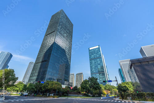 Bottom view of modern skyscrapers in business district against blue sky.