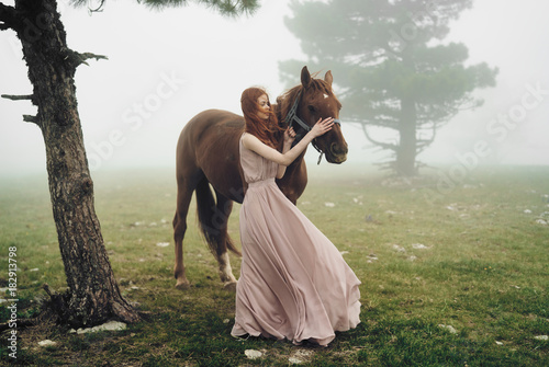 Canvas Print 2043693 Young beautiful woman in pink long dress in peas with a horse