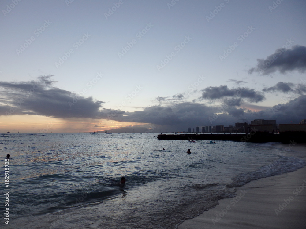 People play in water at dusk on San Souci Beach