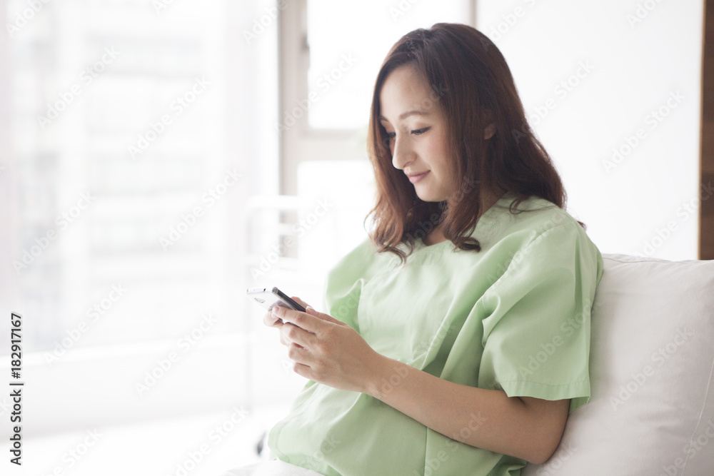 Pre-natal women are using smartphones in the hospital room Pre-natal women are using smartphones in the hospital room