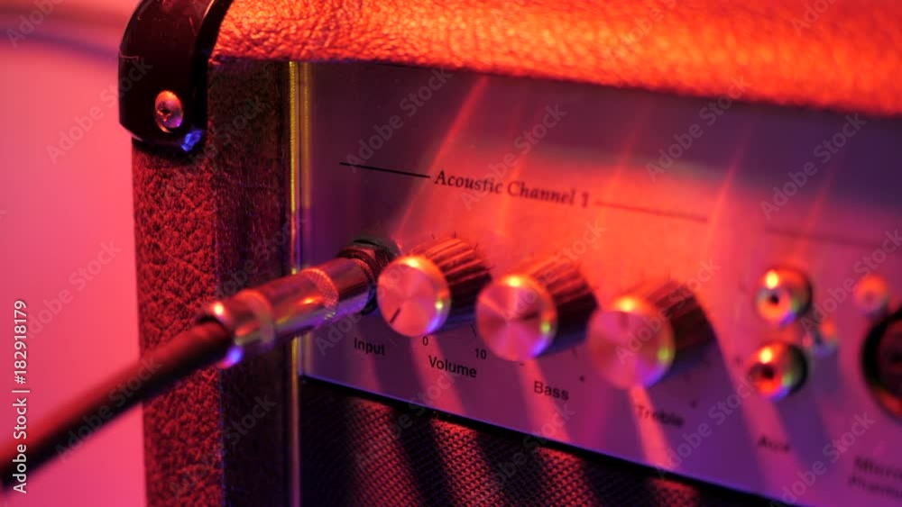 Plugging in cable into the headphone jack of amplifier. Male hand