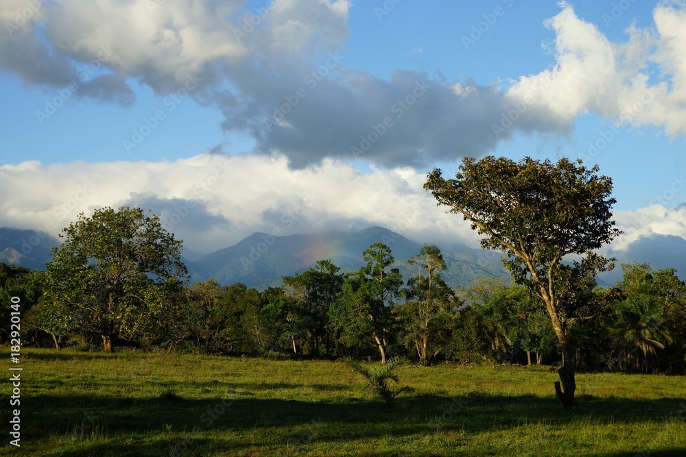 Clouds and mountains with a hint of starting rainbow and lush green vegetation in countryside Panama Clouds and mountains with a hint of starting rainbow and lush green vegetation in countryside Panama