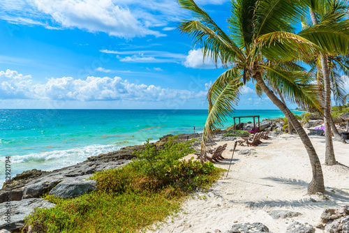Fototapeta Naklejka Na Ścianę i Meble -  Chairs under the palm trees on paradise beach at tropical Resort. Riviera Maya - Caribbean coast at Tulum in Quintana Roo, Mexico