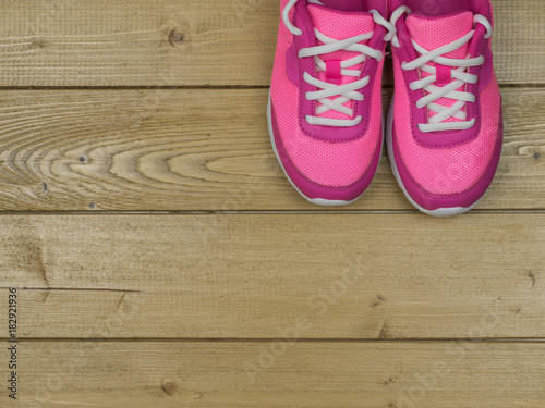 A pair of pink women's shoes on the floor of wooden planks.