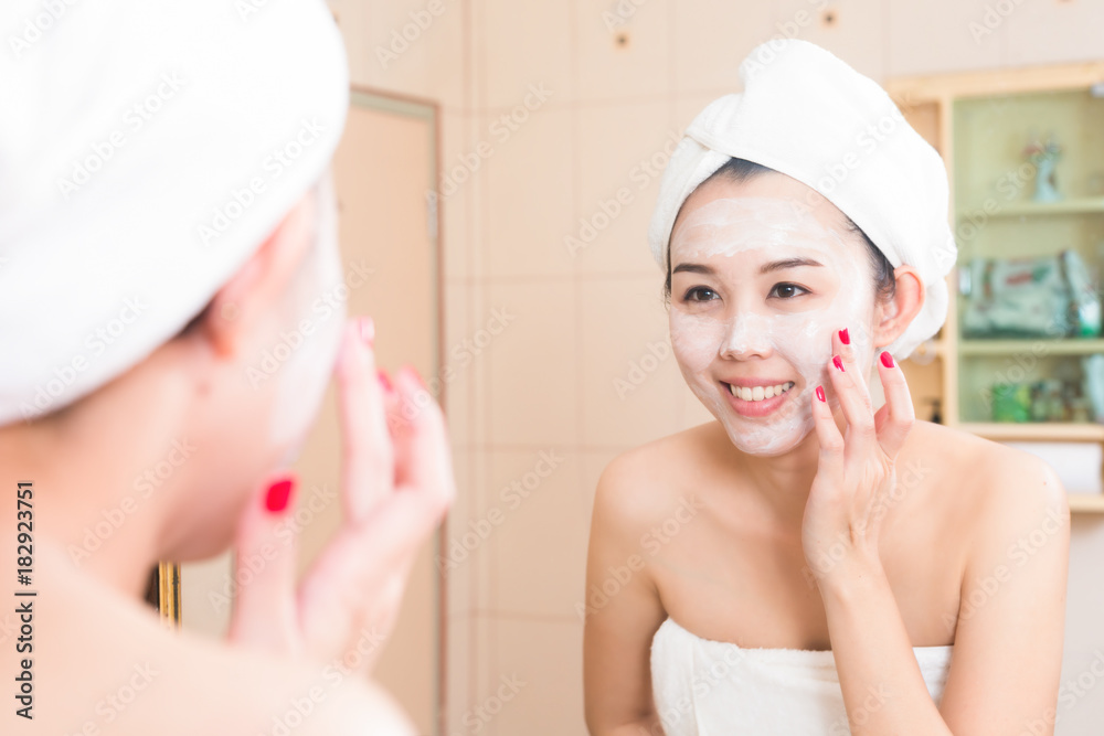 Close-up of beautiful young woman applying cream with bath towel. Close-up of beautiful young woman applying cream with bath towel.