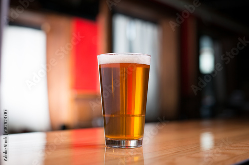 Photographie Pint of pale ale on a wood counter at a bar