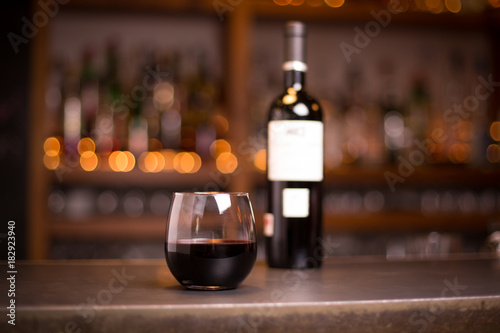 Stemless wine glass with bottle in background