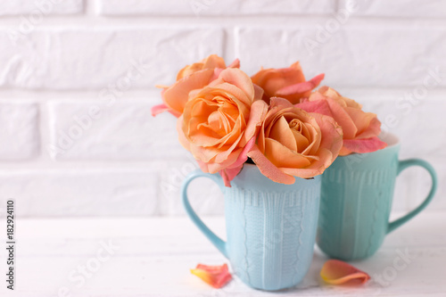 Fresh orange roses in blue cups