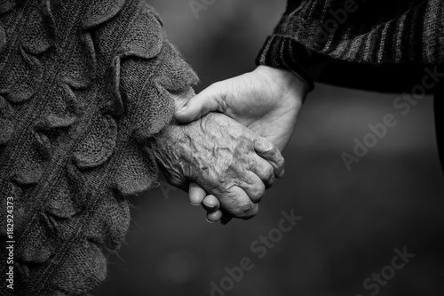 Obraz na płótnie Holding two people hands young and old closeup black and white picture. w salonie