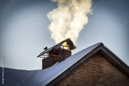 The smoke from the chimney of a private house.
