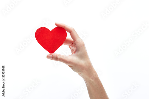 Red heart in woman hand isolated on white