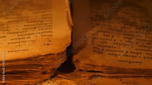 Elderly woman reading old book by candlelight

