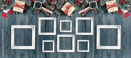 Christmas banner with photo frames, spruce, gift box, Santa Claus boots and scroll in vintage style on wooden boards background