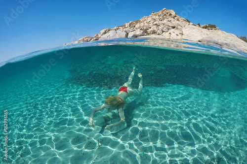 Young woman swims on half underwater photo