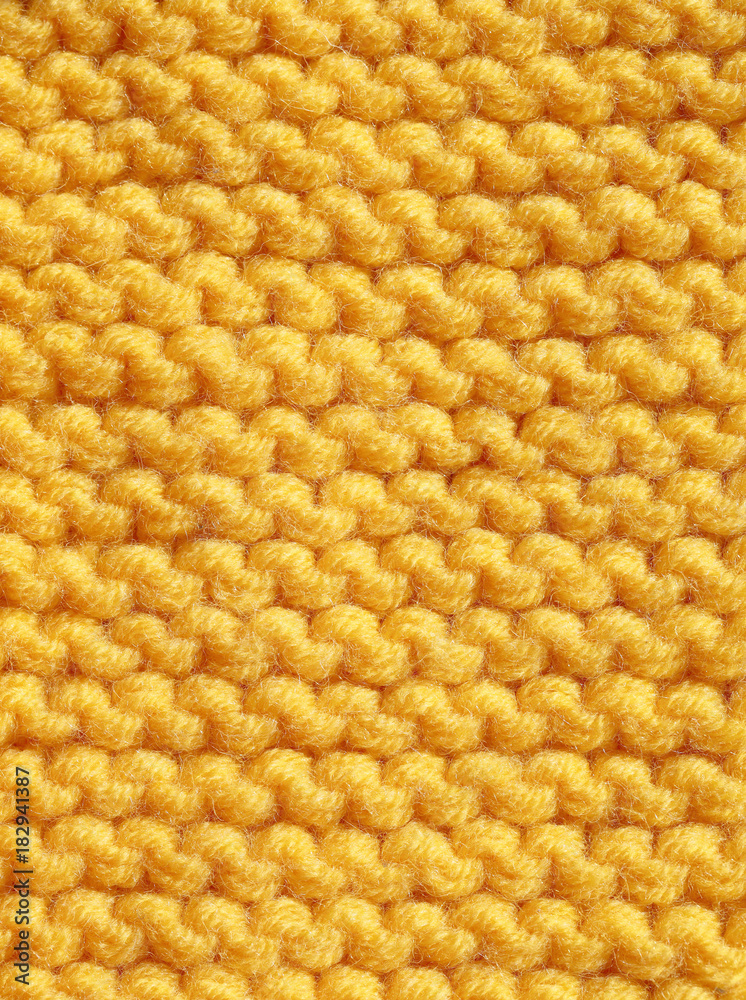 Fototapeta premium Knitting from woolen threads of orange color. Texture of handkerchief cloth.